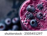 A blueberry smoothie topped with fresh blueberries