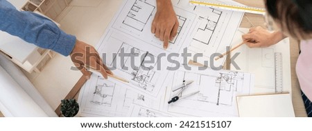 Blueprint architectural document scatter around on meeting table while professional architect engineer hand pointing at blueprint. Creative design teamwork discussion concept. Top view. Burgeoning.