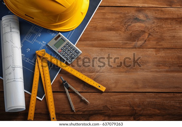 Blueprints and engineer\
equipment on table