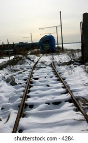 blue-tarped train on snowy tracks