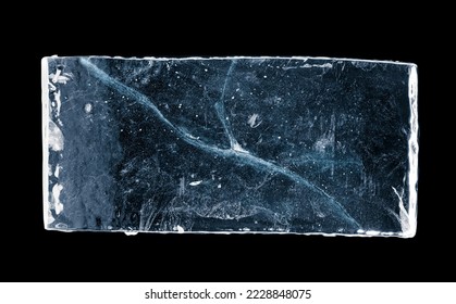 Blue-toned rectangular ice block, with cracks, isolated on black background. Clipping path included.