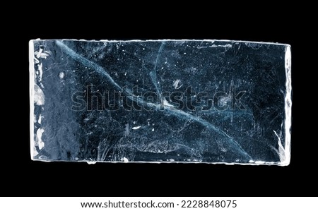 Blue-toned rectangular ice block, with cracks, isolated on black background. Clipping path included.