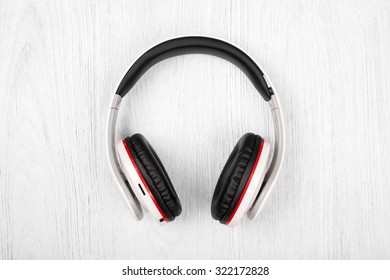Bluetooth headphones on white wood background