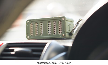 Bluetooth Speaker And Car Entertainment Device Concept - Green Color Bluetooth Speaker On Car Console With Traffic Jam And Copy Space