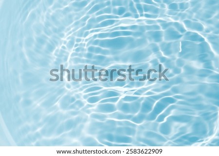Bluewater waves on the surface ripples blurred. Defocus blurred transparent blue colored clear calm water surface texture with splash and bubbles. Water waves with shining pattern texture background.