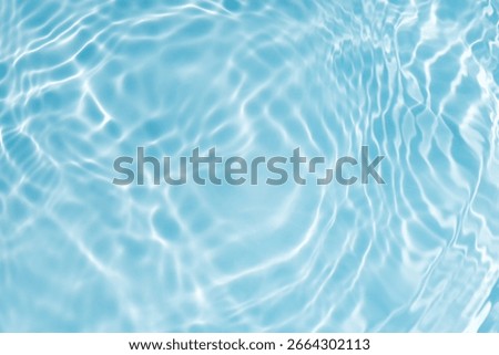 Bluewater waves on the surface ripples blurred. Defocus blurred transparent blue colored clear calm water surface texture with splash and bubbles. Water waves with shining pattern texture background.