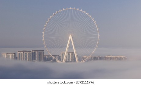 Bluewaters island with modern architecture and ferris wheel covered by morning fog aerial timelapse. New leisure and residential area near Dubai marina and JBR after sunrise - Shutterstock ID 2092111996