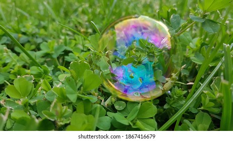 A bluish glitter bubble close up in the grass
