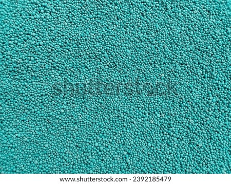 bluish green urea fertilizer granules background. mounds of agricultural medicines to fertilize the soil and plants are small round and smooth