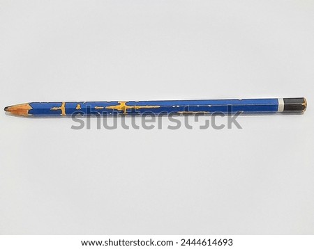A blunt blue pencil with a black tip that had not been used for a long time with eroded marks on the sides