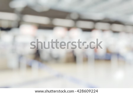Blur abstract background bokeh of Terminal Departure Check-in at airport.Blurry view check in counter row with passengers travelling by plane at air port.Blurred image international airport interior