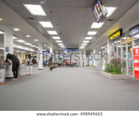 Blur abstract background bokeh of Terminal Departure Check-in at airport.Burry view of check in counter row with passengers travelling by plane at air port.Blurred image international airport interior