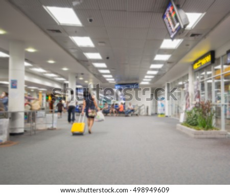 Blur abstract background bokeh of Terminal Departure Check-in at airport.Burry view of check in counter row with passengers travelling by plane at air port.Blurred image international airport interior