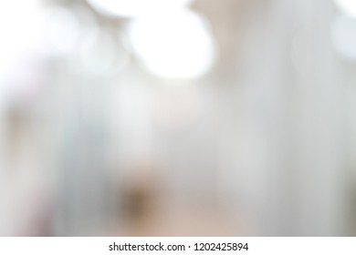 Blur abstract background of corridor in clean hospital. Blurry view of aisle in office with light floor. Defocus walkway in white light building hall.
