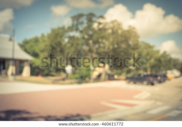 Blur abstract background font view of roadside\
rest area with parking lots and people walk in. A sunny day at a\
service area next to the highway interstate I-10 from Houston to\
San Antonio, TX.Vintage