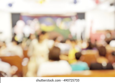 Blur abstract background of people sitting in conference room for open house event at school. Blurry parent teacher meeting. Defocus kid students with parents in church hall.