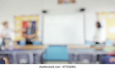 Blur Abstract Background Teacher In Front Of Classroom For Meet The Parent Day. Blurry Teachers Teaching In School. Defocus Open House Day At Campus For Kindergarten Students.