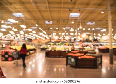 Blur abstract organic fresh produces, fruits and vegetable on shelves in store at Humble, Texas, US. Blurred supermarket, grocery with customers shopping, bokeh light background. Healthy concept.