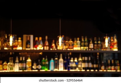 blur alcohol drink on bar counter in the dark night background