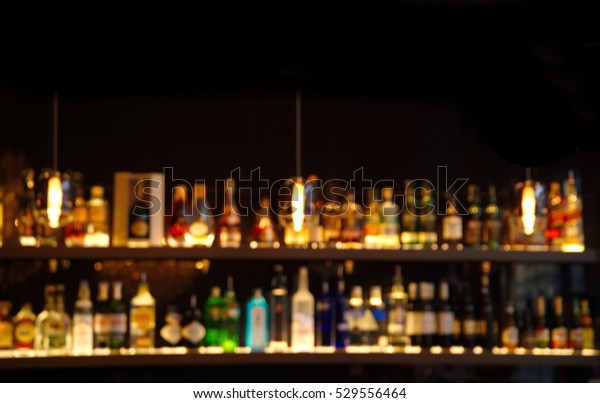 在黑暗的夜晚背景酒吧櫃檯上模糊酒精飲料庫存照片 立刻編輯