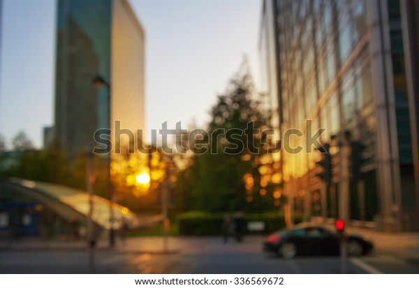 Blur background. Banking\
headqquaters in Canary Wharf. Office building and road with cars at\
sunset 