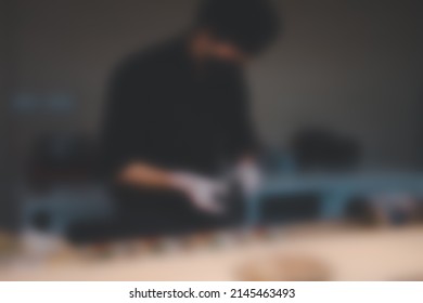 Blur background of chef in uniform wearing black face mask cooking in a commercial kitchen.