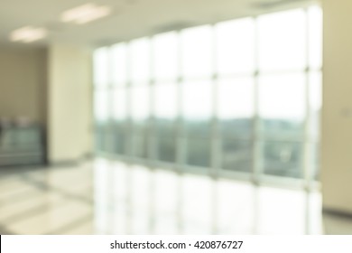 Blur background interior view looking out toward to empty office lobby and entrance doors and glass curtain wall 
