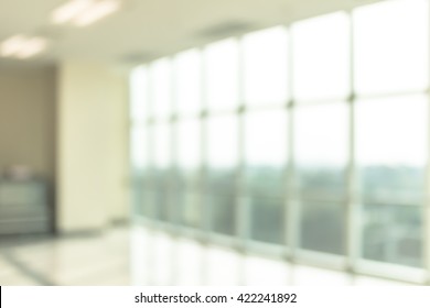Blur background interior view looking out toward to empty office lobby and entrance doors and glass curtain wall 