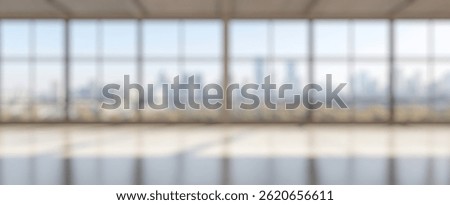 Blur Background of Modern Empty Office Space with Large Windows Overlooking City Skyline on a Bright Sunny Day. Defocused Image for Background.
