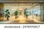 Blur background of modern workplace decorated with green plant. Blurred office corridor with plants and glass walls. Modern office interior concept. Design for poster, wallpaper, banner. Spate.