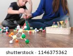 Blur background. Mom and son are doing a volcano experiment. Pour water into the volcano.
