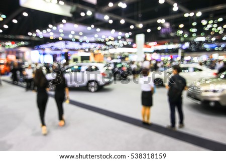 blur background of motorshow, car show room. Abstract blurred image people in cars exhibition show