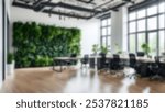 Blur background of office interior with large windows with city urban view, plants, and wooden desks at sunset. Modern workplace and urban greenery concept. Design for poster, wallpaper, Spate.