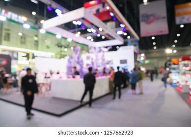 Blur Background Of People In Electronic Fair Expo At Big Exhibition Hall Event Trade Show Room. Meetings, Incentives, Conferences And Exhibitions (MICE) Business And Commercial Trading Concept.