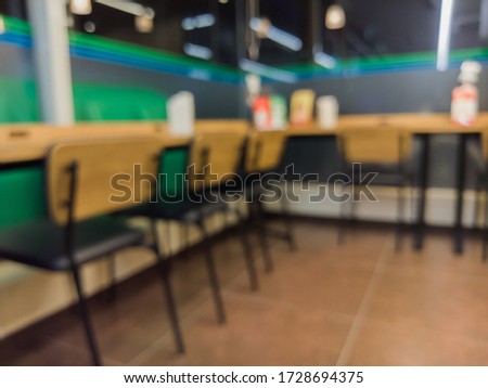 Blur Background of Rows of chairs and table lined up. Seat for eating at Convenience Store. 