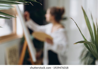 Blur background of young talented painter drawing with brush and color palette on canvas. Concept of art therapy and inspiration. - Shutterstock ID 1929476318