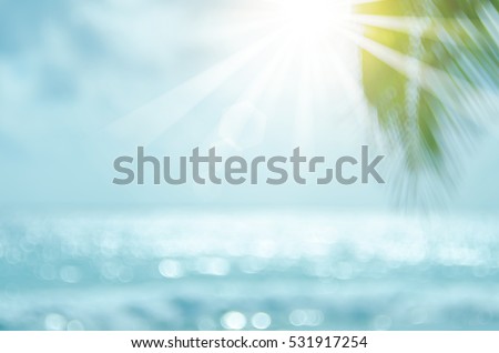 Blur beautiful nature green palm leaf on tropical beach with bokeh sun light wave abstract background. Copy space of summer vacation and business travel concept. Vintage tone filter color style.