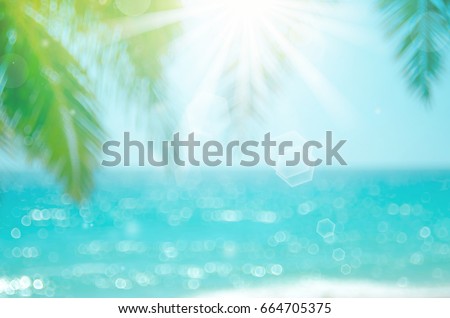 Blur beautiful nature green palm leaf on tropical beach with bokeh sun light wave abstract background. Vintage tone color style.