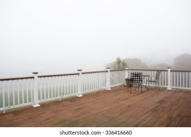 Blur black coffee table at a corner of the old deck in a foggy morning mist background