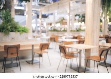 Blur bokeh background of interior table and chair in mall canteen. Abstract bokeh of food business dining court with no person, defocused of light retail lifestyle cafe shop decoration in modern.