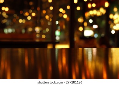 blur bokeh reflection light on table in pub or bar club and restaurant Christmas party and celebrate at dark night for display product in brown tone background 