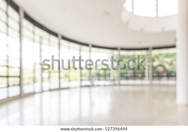 ぼかしたビジネスオフィスの背景に空の白い部屋のロビーホール内部 ガラスの壁の窓とぼかした明るいボケ の写真素材 今すぐ編集