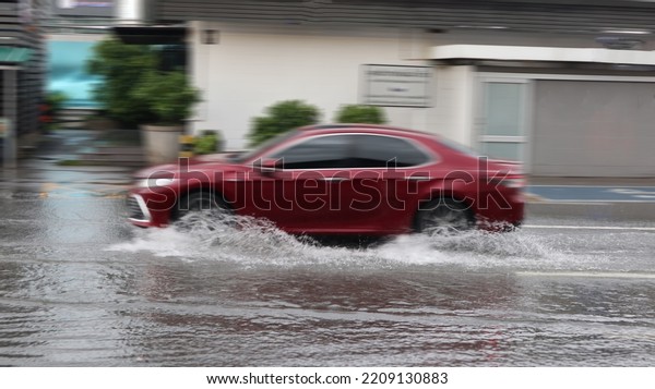 Blur car running and splashing flood water on\
the flooded street which caused by heavy rain and blocked drainage\
pipes.                           \
