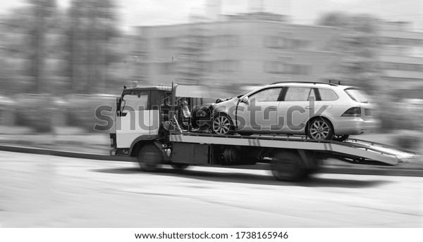Blur, car tow truck\
rides on a city street