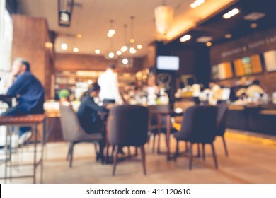 Blur Of Coffee Shop / Cafe Restaurant With Businessman In Light Gold Color Background.For Modern Lifestyle Concept