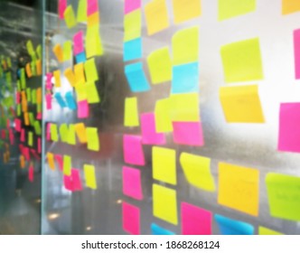 Blur color notes or sticky note on the glass wall in the office during brainstorming session in ideation workshop of design thinking