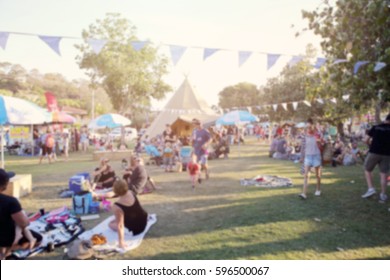 Blur defocused background of people, family in park fair, festive summer, music festival tent - Powered by Shutterstock