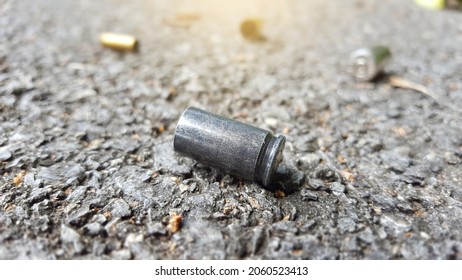 Blur Empty Pistol Bullet Shells On Concrete Ground In A Shooting Crime Scene