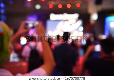 blur event with people background - blurred computer game show festival bokeh  - people and activity on stage - camera man - business concept