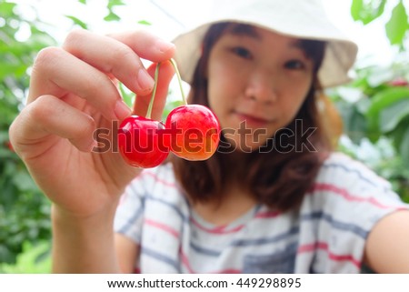 Blur face asian girl smile happily, picking cherry in fruit picking farm at Niki, Hokkaido